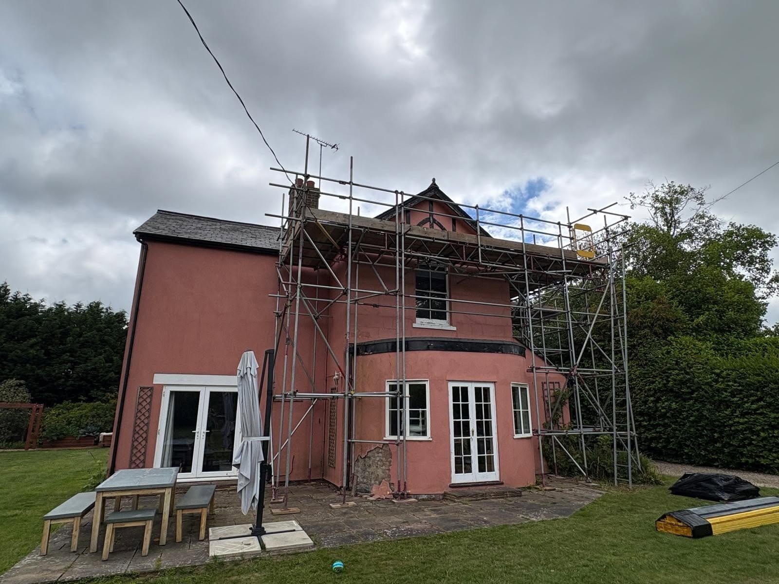 Pink-washed period house under scaffolding