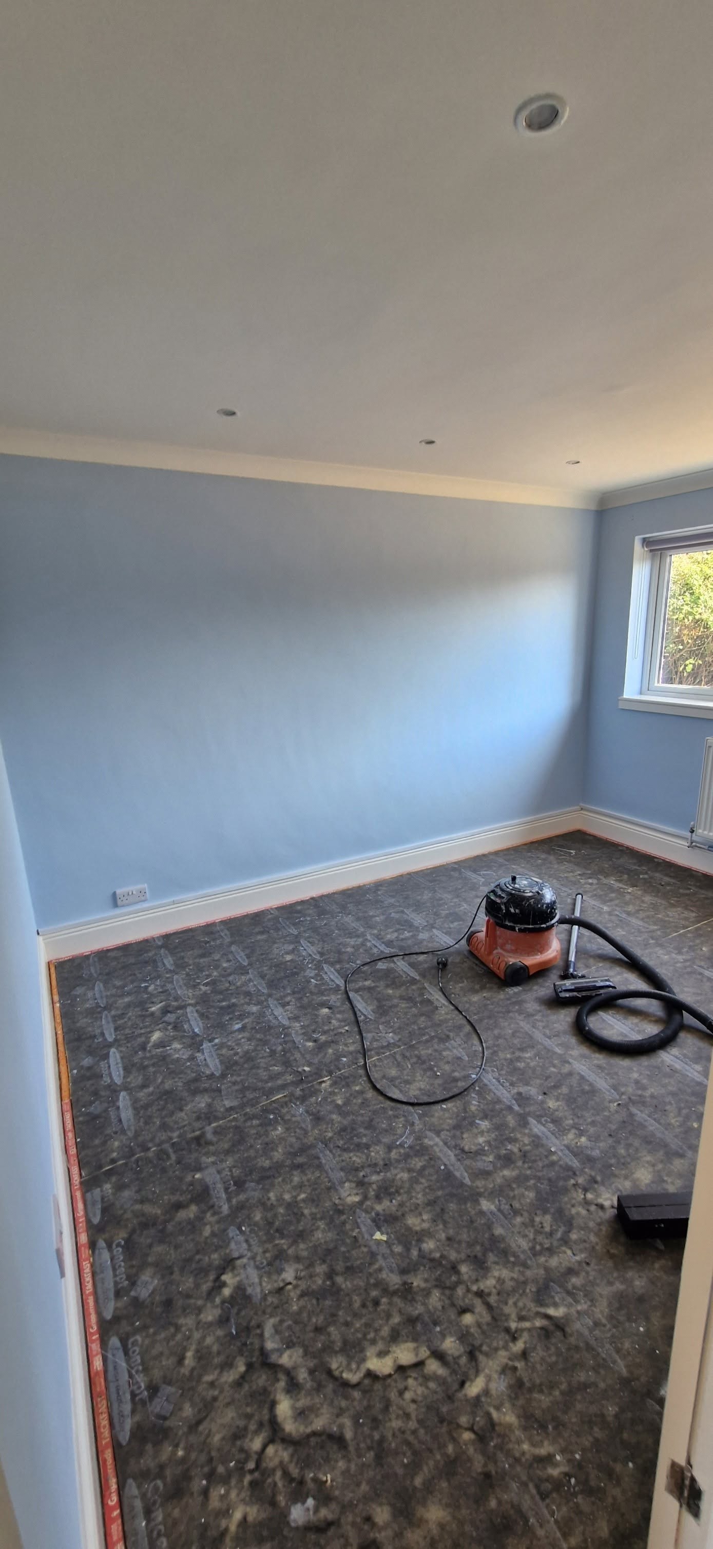 Freshly painted pale blue bedroom with white woodwork