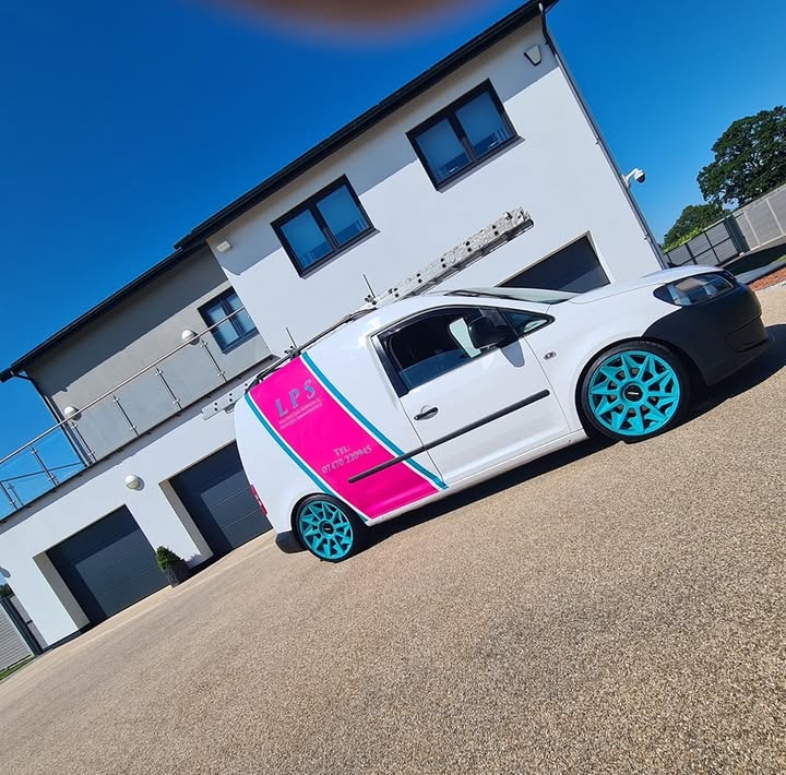 The white LPS van with its pink panel, turquoise stripe and turquoise wheels